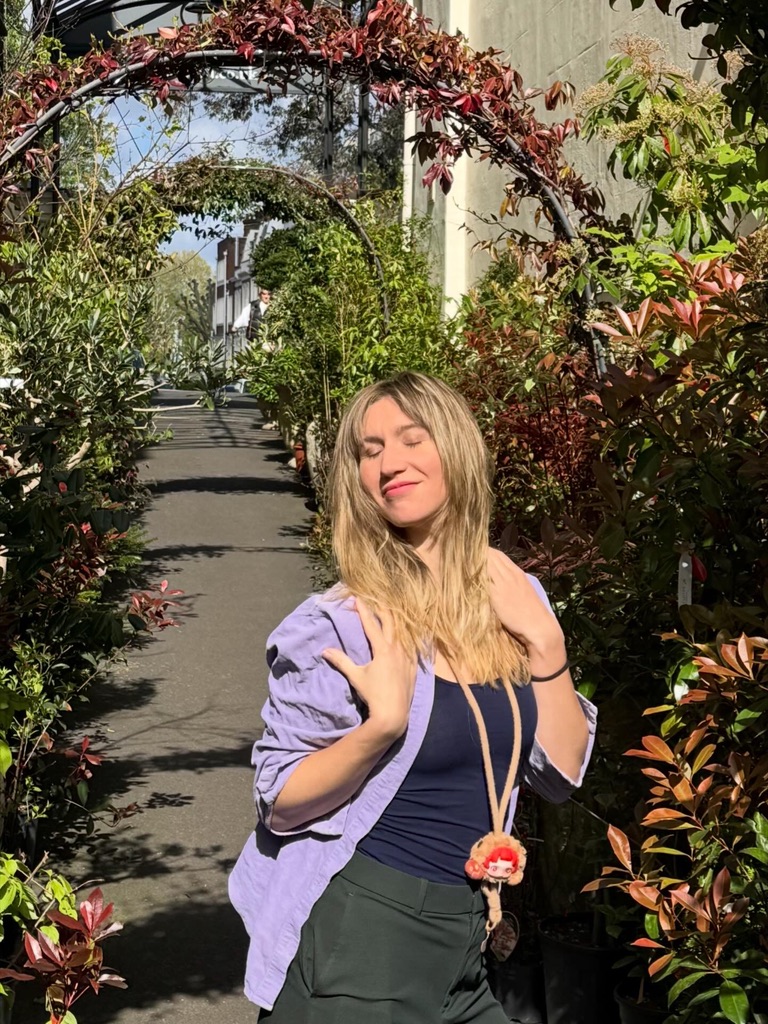 Under a flowering archway, arms up